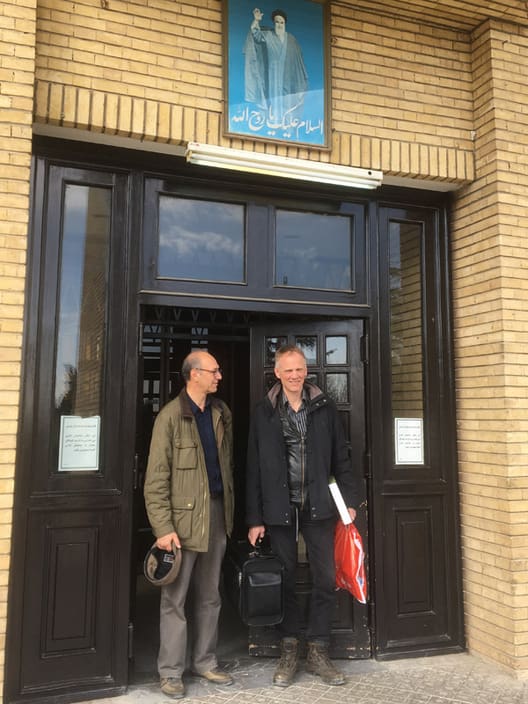 De to projektledere - professorerne Khosro SaghebTalebi og Palle Madsen ved indgangen til universitetets skovbrugs-afdeling. Over døren ayatollah Khomeini