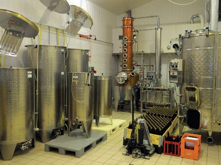 Produktionsfaciliteter med gæringstanke m. m. i baggrunden ses destillationsapparatet, som er indkøbt i Tyskland.